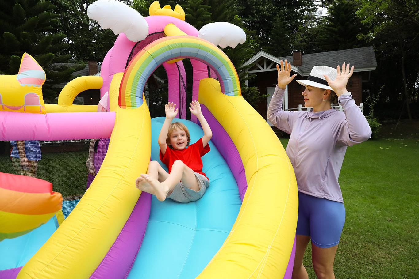 Parent-child bonding as children and parents play on the slides in Unicorn Theme's bouncy house