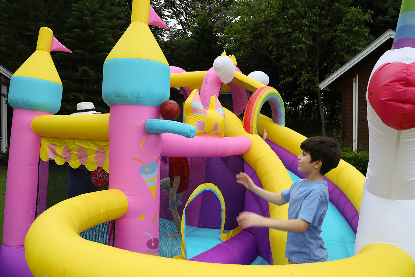 Kids playing basketball in Unicorn Theme's bounce house