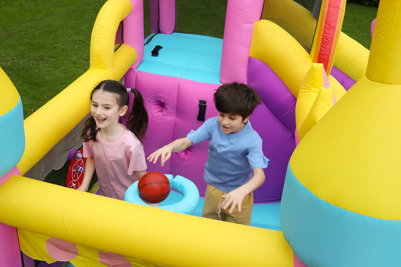Two kids bouncing in a unicorn-themed bouncy house at the same time